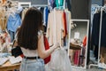 Second hand. Sustainable fashion. Young Latina woman buying used sustainable clothes from second hand charity shop Royalty Free Stock Photo