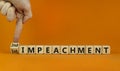 Second impeachment symbol. Businessman turns wooden cubes and changes words 1st impeachment to 2nd impeachment. Beautiful orange