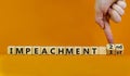 Second impeachment symbol. Businessman turns wooden cubes and changes words 1st impeachment to 2nd impeachment. Beautiful orange