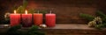 Second Sunday in Advent, four red candles, two of them are burning, fir branches and Christmas decoration on dark rustic wood,
