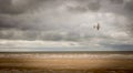 A second world war plane flying through storm clouds on the beach Royalty Free Stock Photo