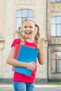 Secondary school student. Cute smiling small child hold books educational institution background. Adorable little girl Royalty Free Stock Photo