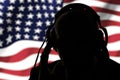 Secret agent in headphones on the background of the American flag Royalty Free Stock Photo