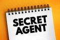 Secret Agent is a spy acting for a country, text concept on notepad Royalty Free Stock Photo