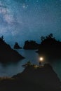 Secret Beach Oregon at Night with Stars and hiker Standing with the Light Royalty Free Stock Photo
