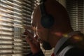 A secret FBI agent Peeps through the blinds and overhears a conversation in headphones