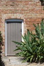 The secret garden. Locked wooden gate in a red-brick wall Royalty Free Stock Photo