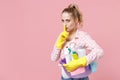 Secret girl housewife in rubber gloves hold basin with detergent bottles washing cleansers doing housework isolated on Royalty Free Stock Photo