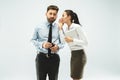 The young woman whispering a secret behind her hand over white background Royalty Free Stock Photo