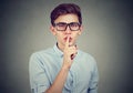 Secret guy. Man saying hush be quiet with finger on lips gesture looking at camera Royalty Free Stock Photo