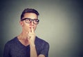 Secret guy. Man saying hush be quiet with finger on lips gesture looking to the side Royalty Free Stock Photo