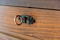 Secret, mystery concept. Close up view of a retro key on an old fashioned keyhole, wooden drawer background