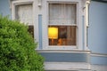 Secret window with hidden library and single lamp lit in house or home in the suburban neighborhoods of the modern city