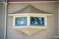 Secret window on hidden side of the house with rain gutter and panoramic view with mini roof and timber or wood pannel Royalty Free Stock Photo