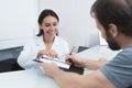 The secretary in a medical clinic helps the patient complete the necessary forms before starting treatment.