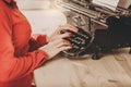 Secretary at old typewriter with telephone. Young woman using ty Royalty Free Stock Photo