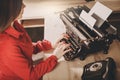 Secretary at old typewriter with telephone. Young woman using ty Royalty Free Stock Photo
