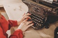 Secretary at old typewriter with telephone. Young woman using ty Royalty Free Stock Photo