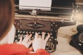 Secretary at old typewriter with telephone. Young woman using ty Royalty Free Stock Photo