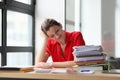 Secretary sits at table near stack of folders with materials Royalty Free Stock Photo