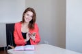 Secretary talking on mobile phone and writing notes while sitting at her desk. Royalty Free Stock Photo