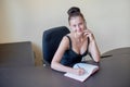 Secretary talking on mobile phone and writing notes while sitting at her desk. Royalty Free Stock Photo