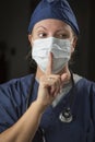 Secretive Female Doctor with Finger in Front of Mouth