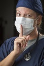 Secretive Female Doctor with Finger in Front of Mouth