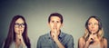 Secretive young people man and two women with finger to lips gesture Royalty Free Stock Photo