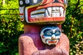 A section of the the colorful `Thunderbird House Post Totem Pole` depicting a Grizzly bear holding a human H