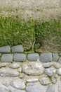 Section of a decorative weathered old wall by the sea in Normandy, stone in part concrete, with algae and moss, copy space, space