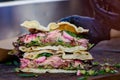 Section of a fresh healthy sandwich or burger cut in two sides, prepared with salmon guacamole and green salad on a brown wooden t Royalty Free Stock Photo