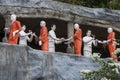 A section of the Golden Temple depicting Buddhist monk statues receiving offerings. Royalty Free Stock Photo