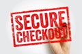 SECURE CHECKOUT stamp printed in bold distressed red letters within a bordered frame, shown being created by a visible hand Royalty Free Stock Photo