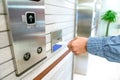 securing lift or elevator access control, man's hand is holding a key card lay up to insert in card hold for unlocking elevator