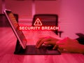 Security breach warning on digital tablet screen computer with red alert. Data theft, cyber attacks, and unauthorized access. Royalty Free Stock Photo