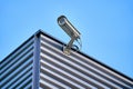 Security camera installed on the building wall in the city against blue sky Royalty Free Stock Photo
