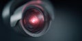 Close-up view of a security camera lens with glowing red light in a dark setting during nighttime surveillance Royalty Free Stock Photo