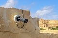 Security Camera on Old Stone Wall Facing Historic Building Royalty Free Stock Photo