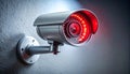 Security camera with red LED light mounted on gray textured wall Royalty Free Stock Photo