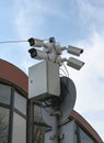 Security cameras mounted on a pole outside a modern building during a cloudy day in an urban area Royalty Free Stock Photo