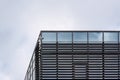 Security CCTV camera on roof corner of modern glass and steel building, overcast sky space for text in background Royalty Free Stock Photo