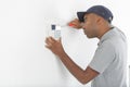 Security consultant fitting burglar alarm sensor in room Royalty Free Stock Photo