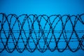 Security fence barbed wire blue sky background