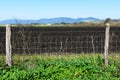 Security fence protects agricultural field plowed and prepared for planting crops in spring