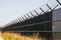 Security fence topped with barbed wire. Royalty Free Stock Photo