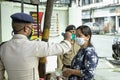 A Security Guard checking temperature of a lady before giving permission to enter in office in india.