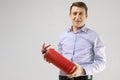 Young man holding a fire extinguisher in his hands isolated on a light background Royalty Free Stock Photo