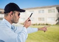 Security guard holding walkie talkie and gesturing while standing on field Royalty Free Stock Photo