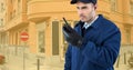 Security guard holding walkie talkie while standing on road against buildings Royalty Free Stock Photo